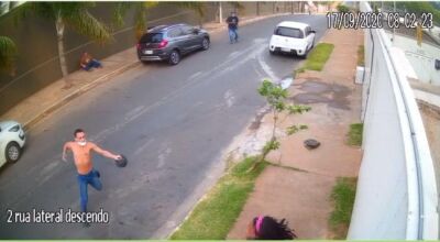 Assaltante magro está com um revólver na mão direito e boné na esquerda