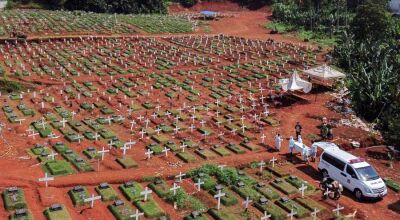 Vista aérea de um cemitério em Jacarta, na Indonésia, mostra coveiros com roupas de proteção carregar um caixão com uma vítima de Covid durante a pandemia do novo coronavírus Foto: Willy Kurniawan/Reuters