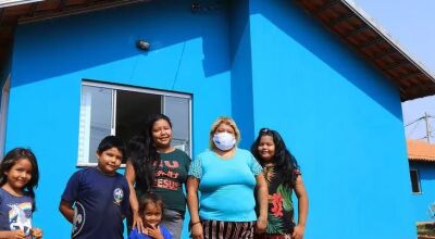 Família indígena pega a chave de casa entregue, no ano passado, na Aldeia Água Bonita (Foto: Divulgação/Governo do Estado)