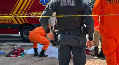 Corpo da vítima no chão e equipes da PM e bombeiros no local. (Foto: Marcos Maluf)