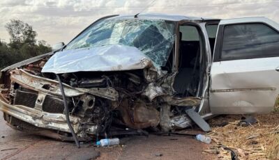 Carro desvia de buraco, bate em carreta e fica destruído