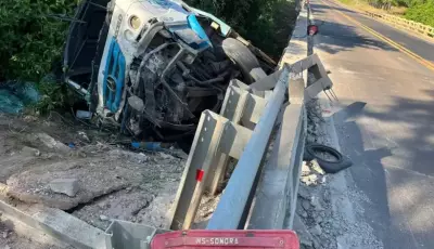 Caminhão despenca de ponte e motorista fica preso às ferragens