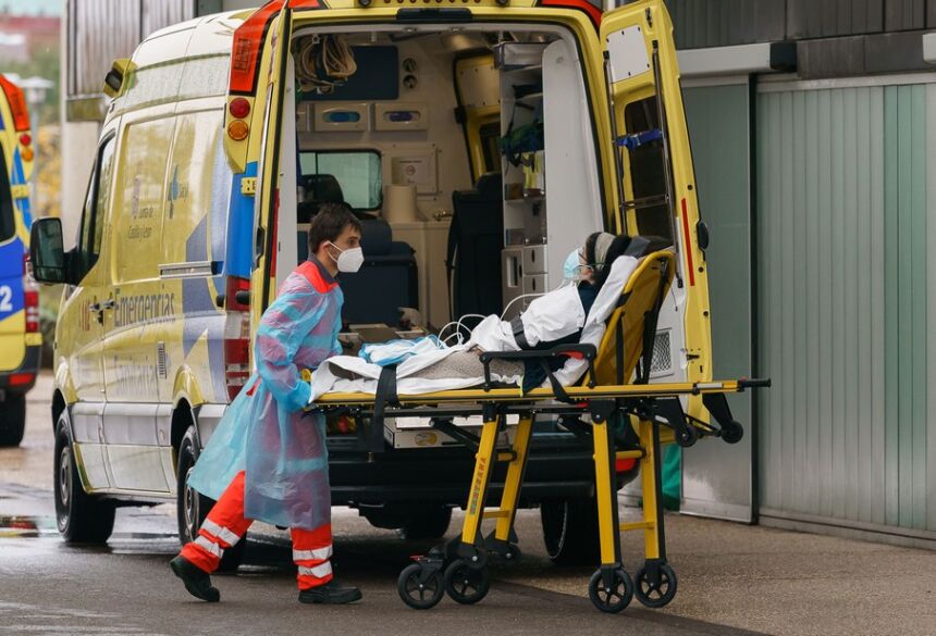 Paramédico retira mulher de uma ambulância na entrada de hospital em Burgos, na Espanha, na quarta-feira (21)  Foto: Cesar Manso/AFP