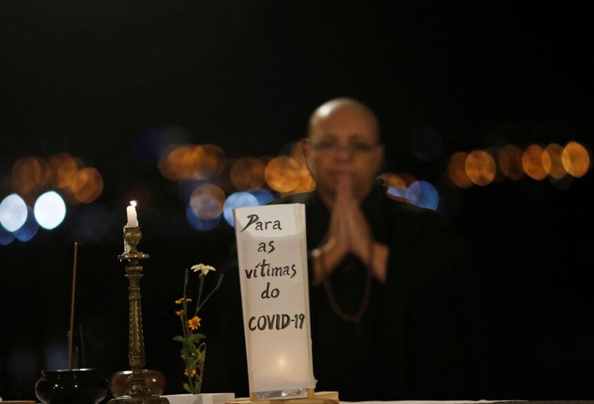 Monja budista reza em uma cerimônia japonesa antes de soltar lanternas na água em Brasília com nomes de pessoas que morreram de Covid-19, no dia 30 de novembro.  