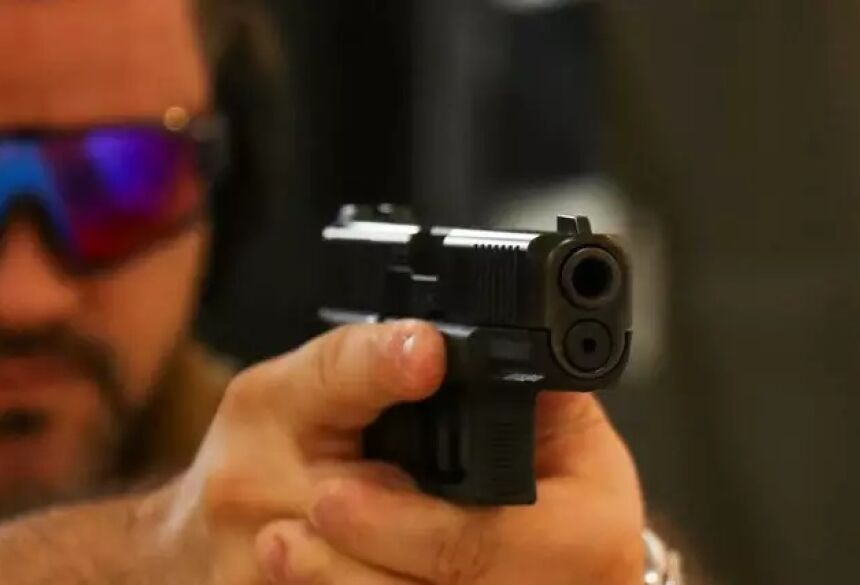 Homem manuseia arma em clube de tiro de Campo Grande. (Foto: Henrique Kawaminami) - CREDITO: CAMPO GRANDE NEWS
