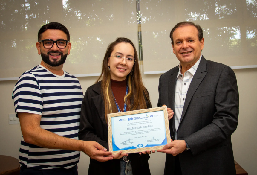 A acadêmica Júlia Iapechino celebra a conquista ao lado do Reitor da UNIGRAN, Renato Aguiar e do coordenador de Administração, Valdir Pereira