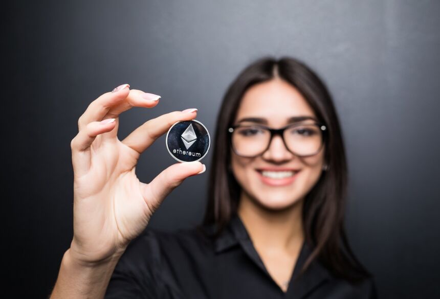Mulher de negócios jovem em copos com Litecoin nas mãos isoladas na parede preta - Foto: freepik / diana.grytsku