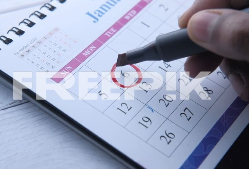 CALENDÁRIO - Fecho do círculo da mão da pessoa na data de calendário / Foto: Getty Images / freepik.com