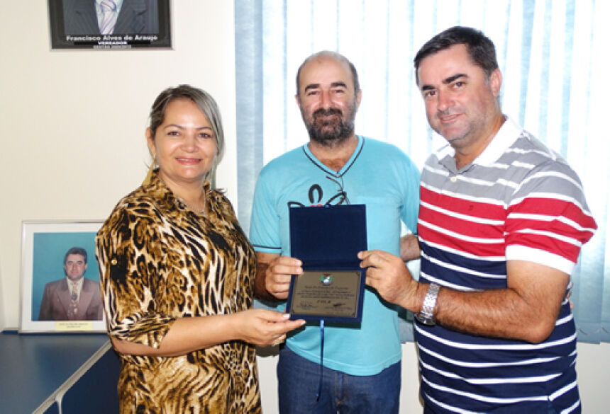 Vereadores Rose Mônica e Francisco "Tiquinho" entregam Título ao homenageado (ao centro)