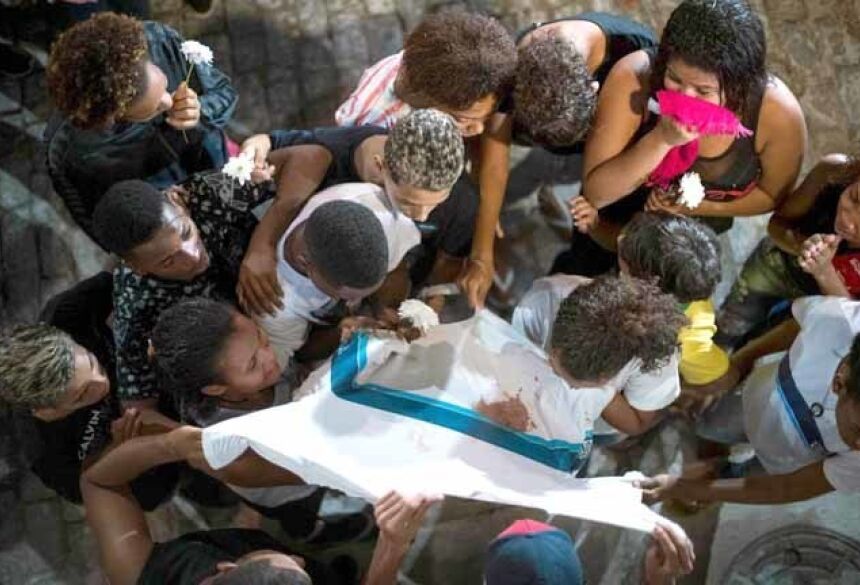Amigos e familiares de Marcos Vinícios choram sobre sua camiseta da escola manchada de sangue, nesta quinta-feira. MAURO PIMENTEL AFP
