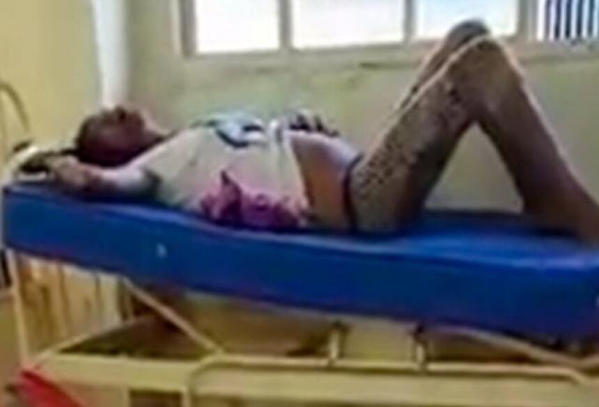 Mulher deitada em cama de CRS aguardando atendimento ao lado de feto (Foto: Reprodução)