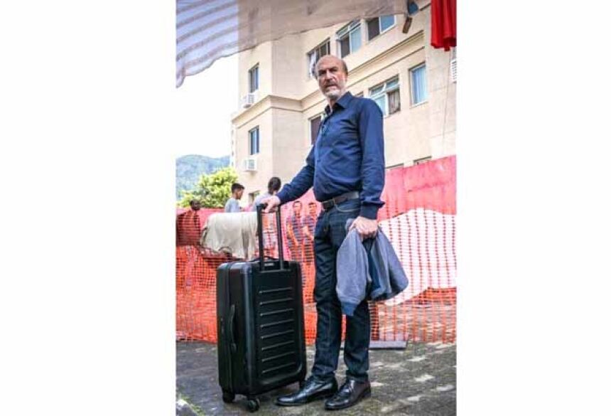 Severo chega com sua mala em prédio condenado, em "Segundo sol" Foto: Raquel Cunha/Rede Globo/Divulgação