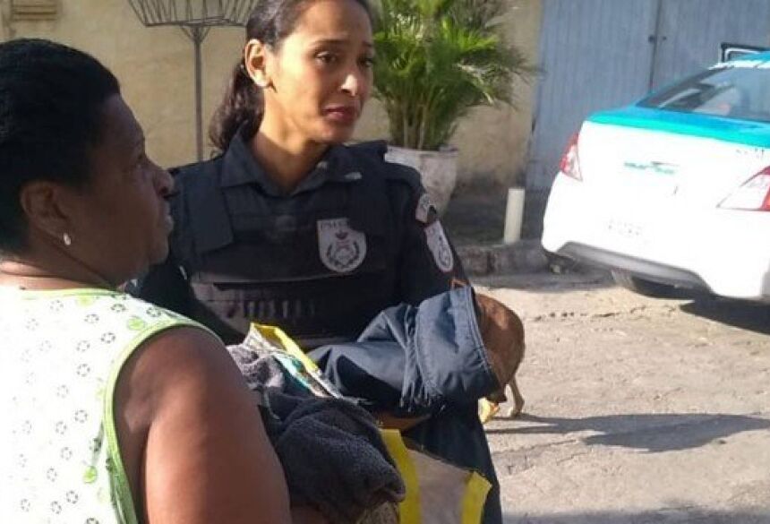 Uma policial com o bebê no colo Foto: Polícia Militar / Divulgação