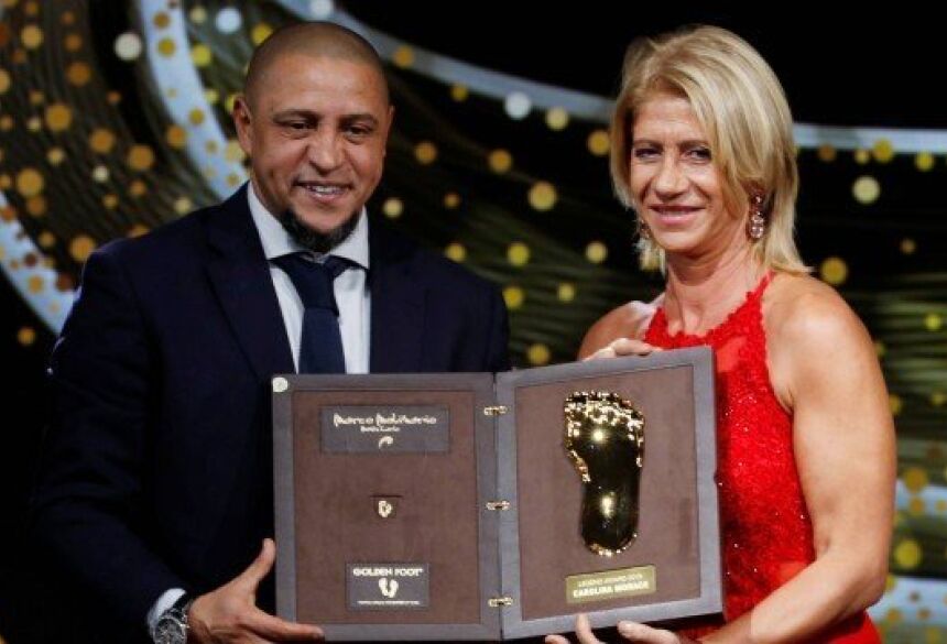 Roberto Carlos entrega prêmio à ex-jogadora e técnica italiana Carolina Morace durante o prêmio Chuteira de Ouro Foto: ERIC GAILLARD / REUTERS