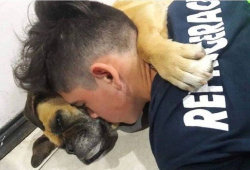 Jovem abraçado à cadela Magui, que morreu após sofrer com fogos de artifícios Foto: Reprodução / Facebook