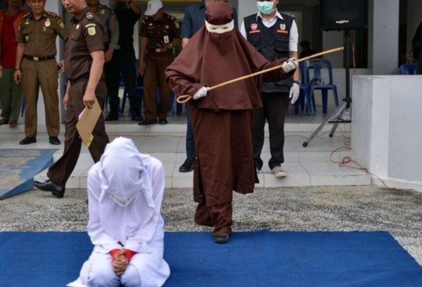 Açoitadora se prepara para punir criminosa sexual na Indonésia Foto: AFP