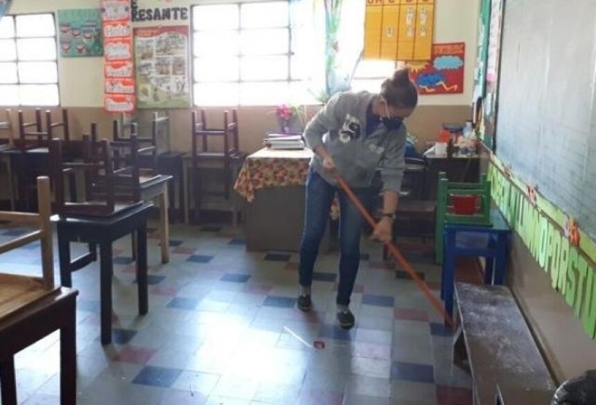 Funcionária de escola limpando sala de aula com máscara de proteção. (Foto: Letícia Barros/ABC Color)